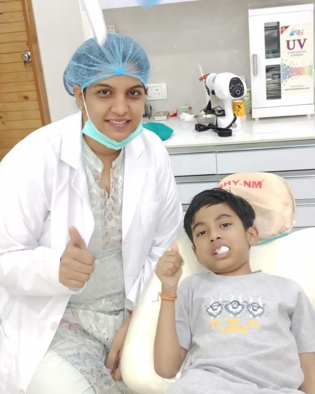 A young patient giving a thumbs up after treatment with the dentist
