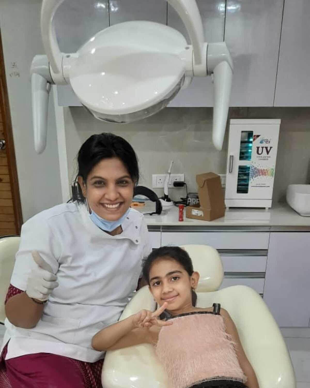 A relaxed young patient in the dental chair with her dentist at Mahavirai Dental