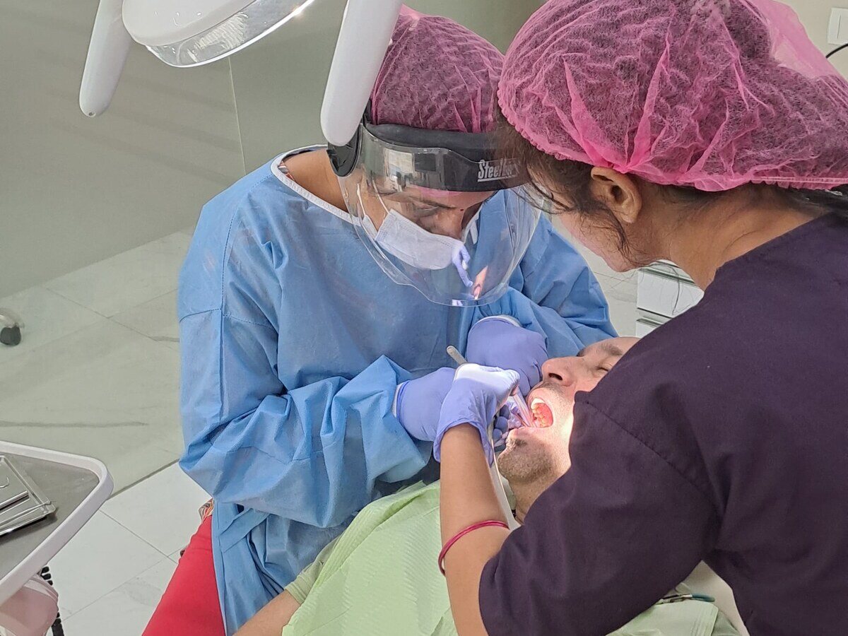 Dr. Shipra Jain and an assistant performing a procedure under magnification at Mahavirai Dental