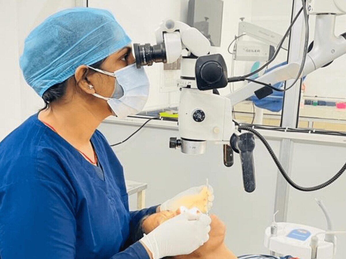 Dr. Shipra Jain working under a dental operating microscope at Mahavirai Dental, Gurgaon