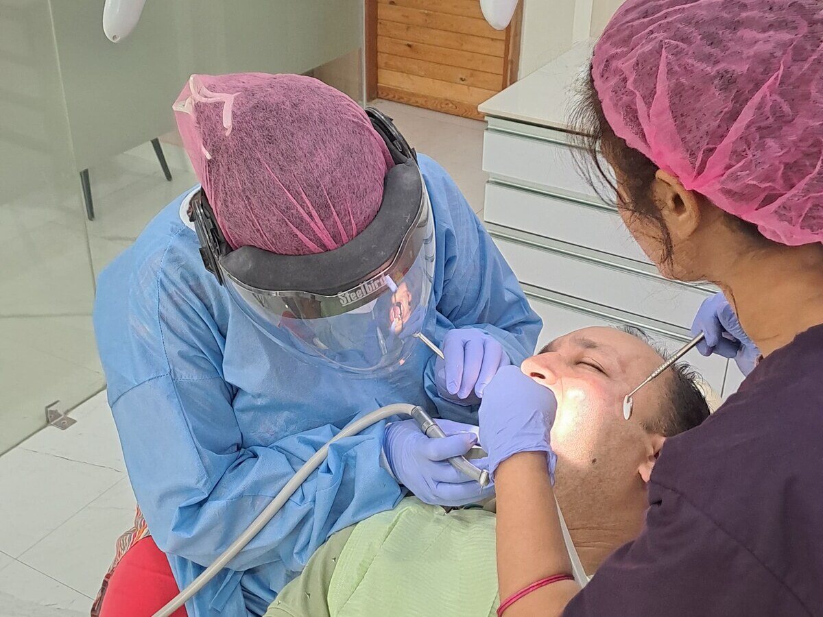 Root canal treatment being carried out under magnification with an assistant at Mahavirai Dental